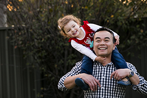 Man with little girl on his shoulders, smiling