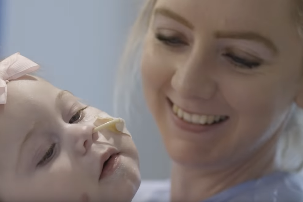 Female nurse and baby with feeding tube