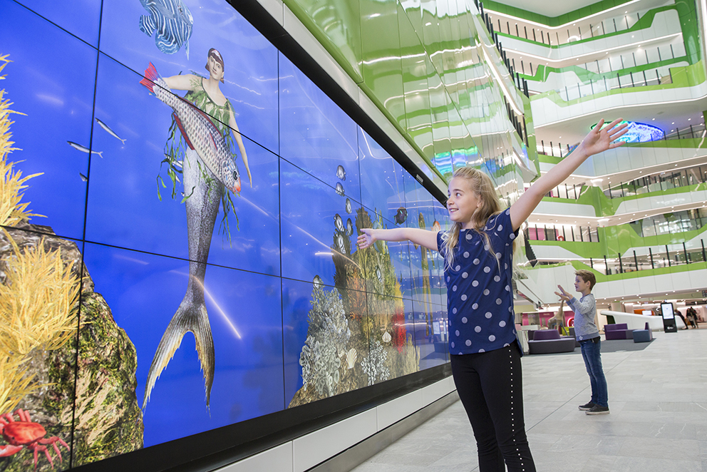 Children play in front of PCH's interactive digital wall