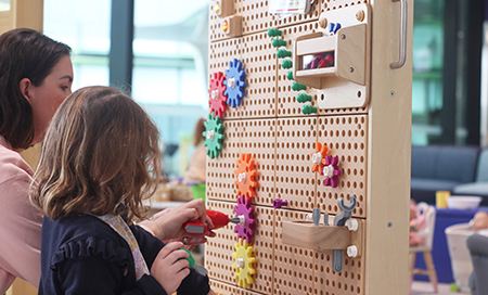 Child at wooden toy wall